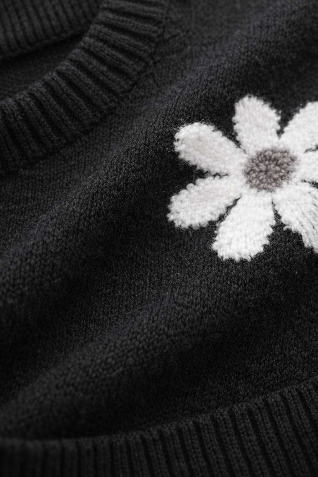 Black sweater with a white embroidered flower detail