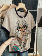 Sweater with cartoon character design held by a hand in a clothing store.