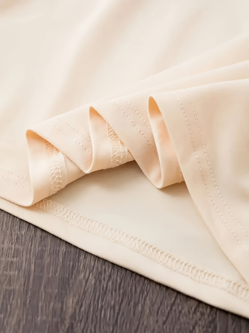 Folded beige fabric on a wooden surface