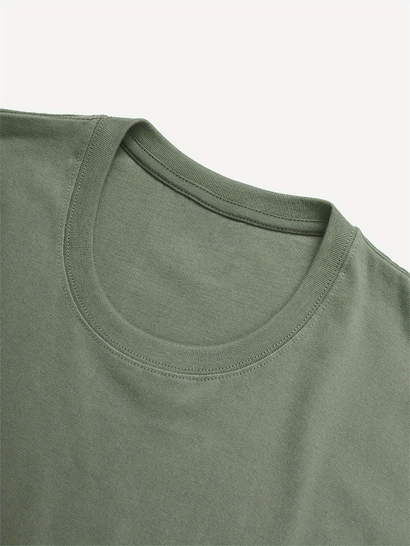 Close-up of a green t-shirt with a plain background