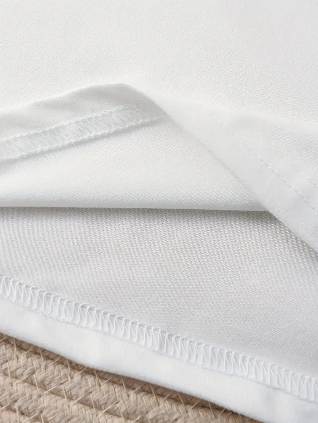 Close-up of a white fabric with a textured edge on a neutral background