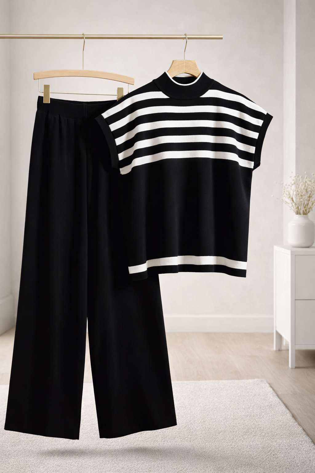 Black and white striped top and wide-leg pants on hangers against a light background
