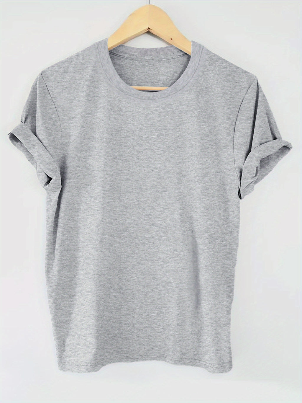 Gray t-shirt on a wooden hanger against a white background