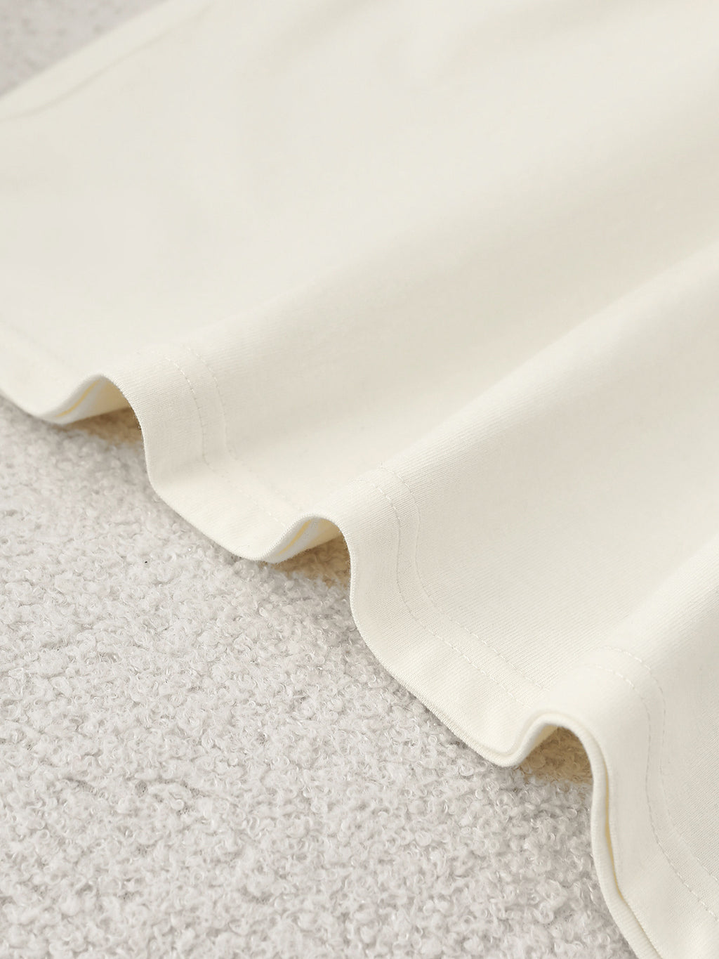 Close-up of a textured white fabric on a light gray surface