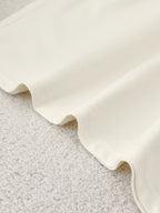 Close-up of a textured white fabric on a light gray surface