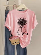 Pink t-shirt with 'I'm Fine' graphic design on a hanger with jeans and a basket.