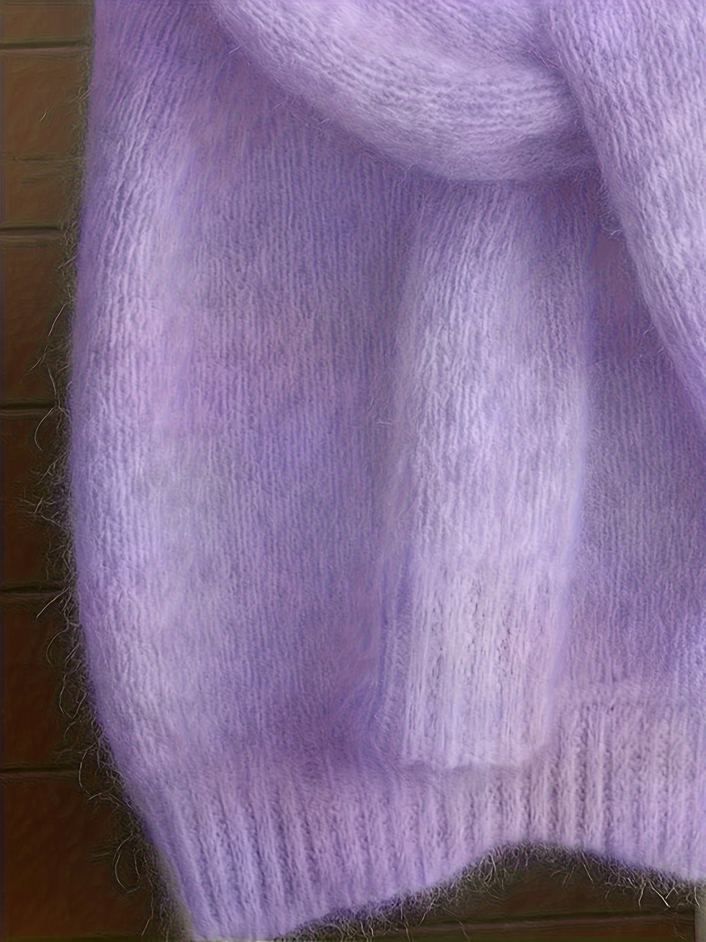 Close-up of a soft, textured purple fabric on a wooden surface