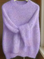 Purple sweater on a hanger against a wooden background