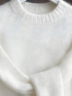 Close-up of a white sweater with ribbed texture