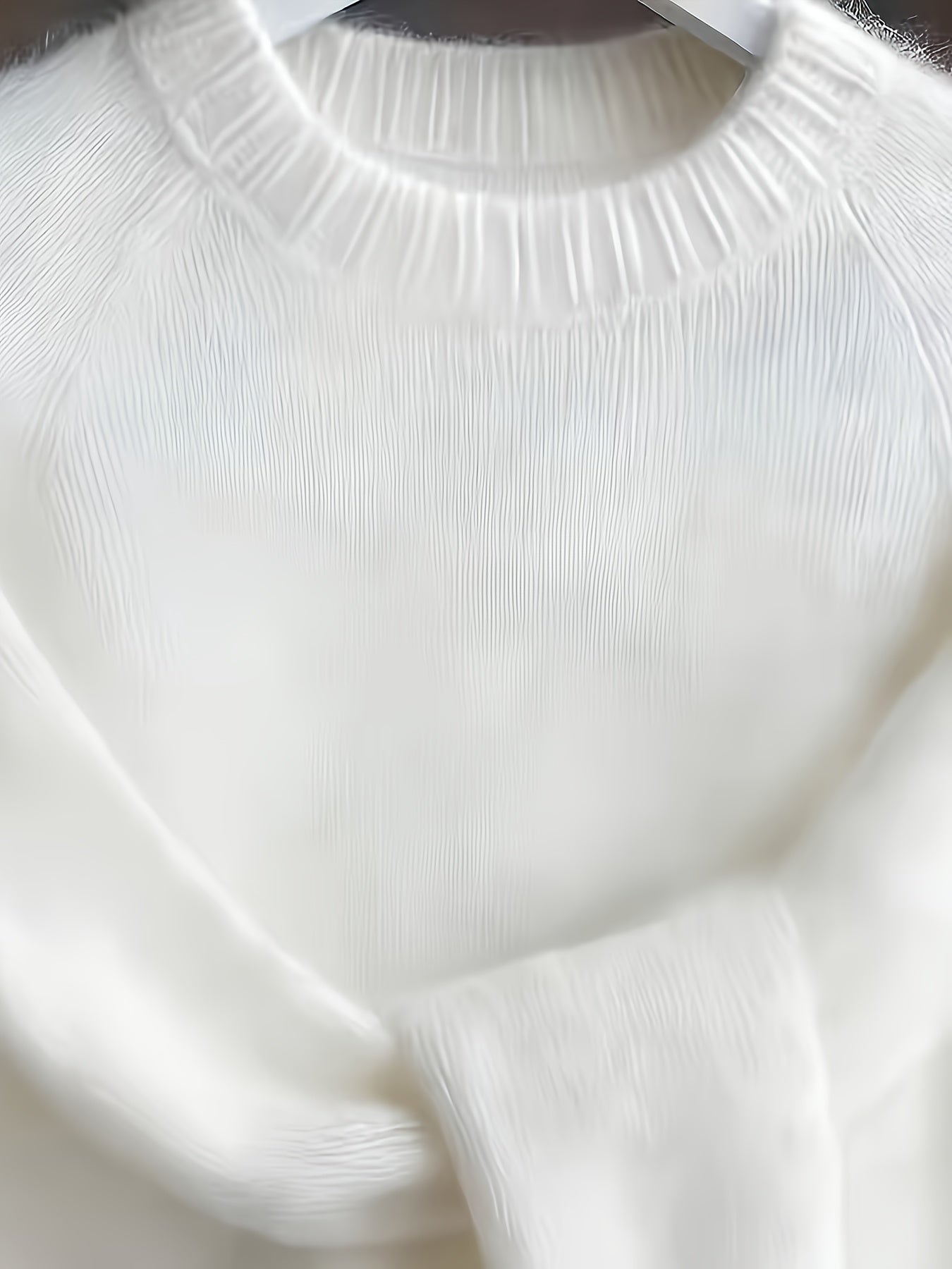 Close-up of a white sweater with ribbed texture