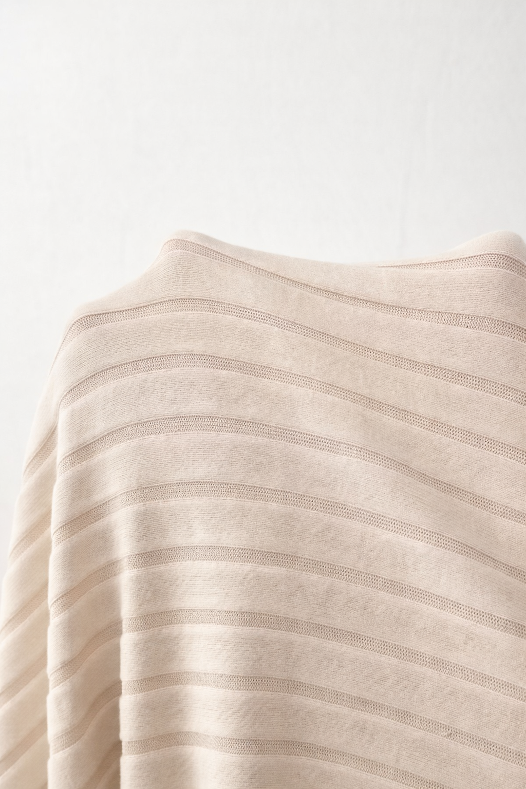 Close-up of a beige fabric with subtle stripes on a white background