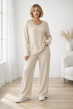 Woman wearing a beige ribbed lounge set in a bright room with white walls and wooden floor.