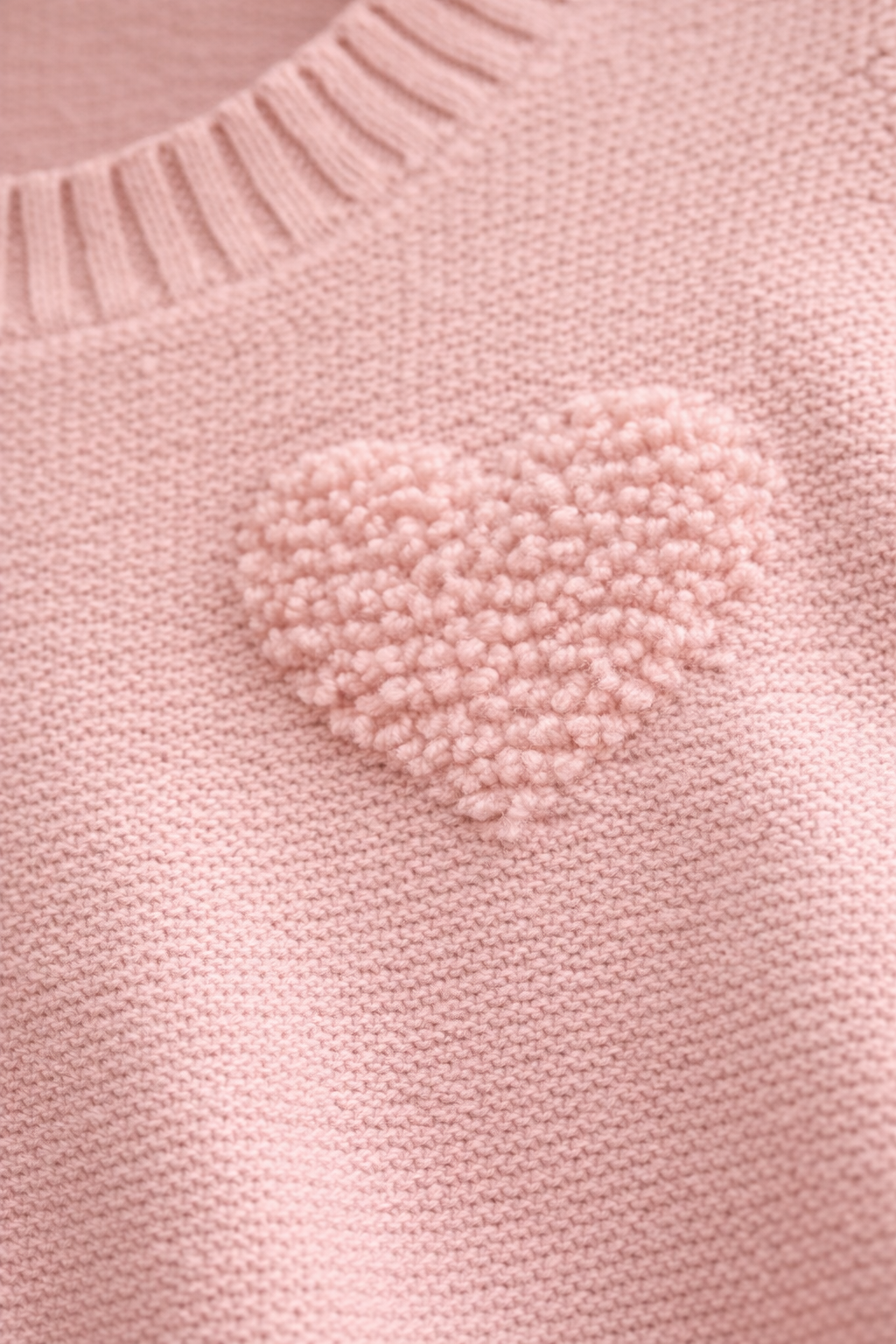 Pink sweater with a heart-shaped pom-pom detail