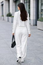 Woman in a white outfit walking on a city street.