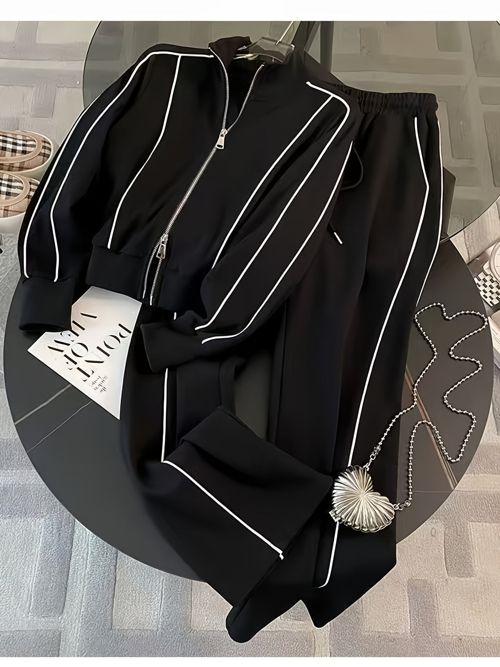 Black outfit with white piping on a round black table.