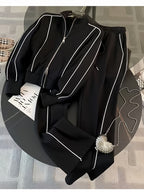Black outfit with white piping on a round black table.