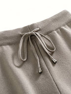 Close-up of gray sweatpants with a drawstring on a white background