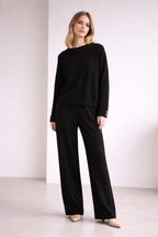 Woman wearing a black outfit against a white background