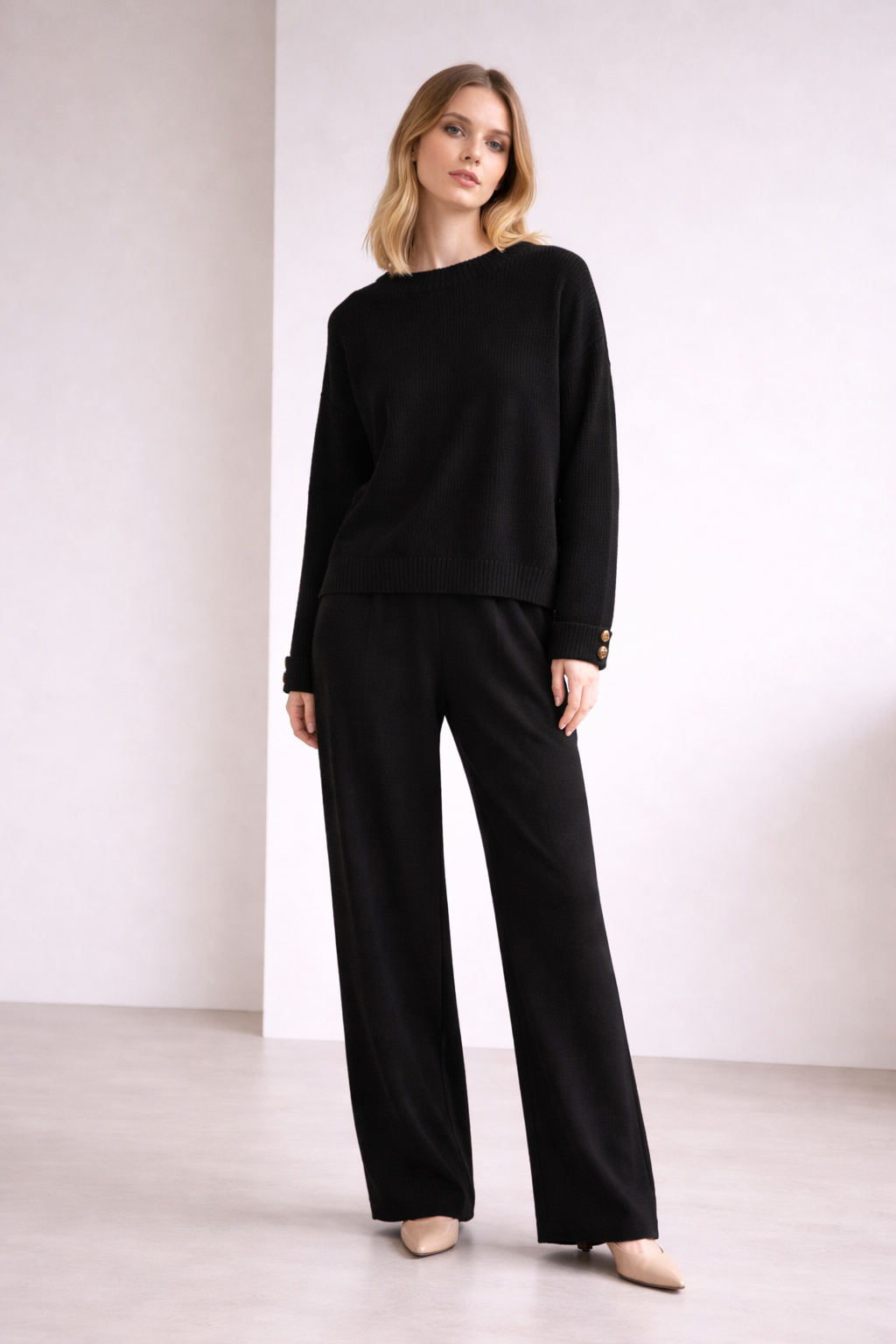 Woman wearing a black outfit against a white background