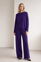 Woman wearing a purple outfit against a plain background