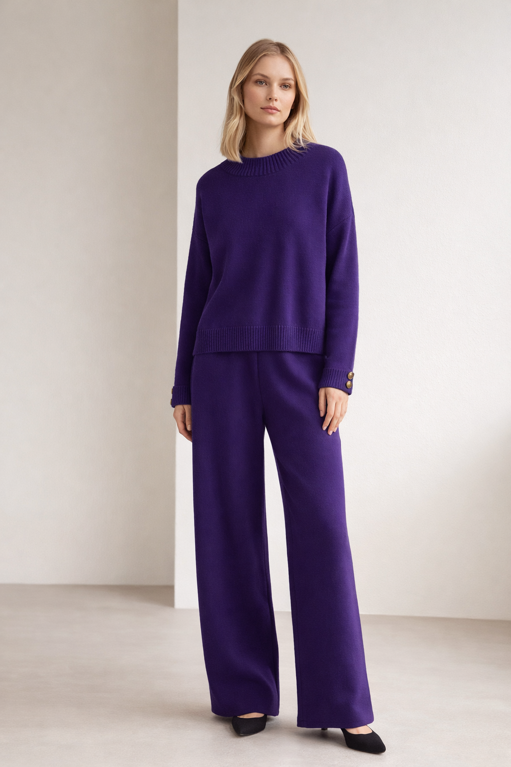 Woman wearing a purple outfit against a plain background