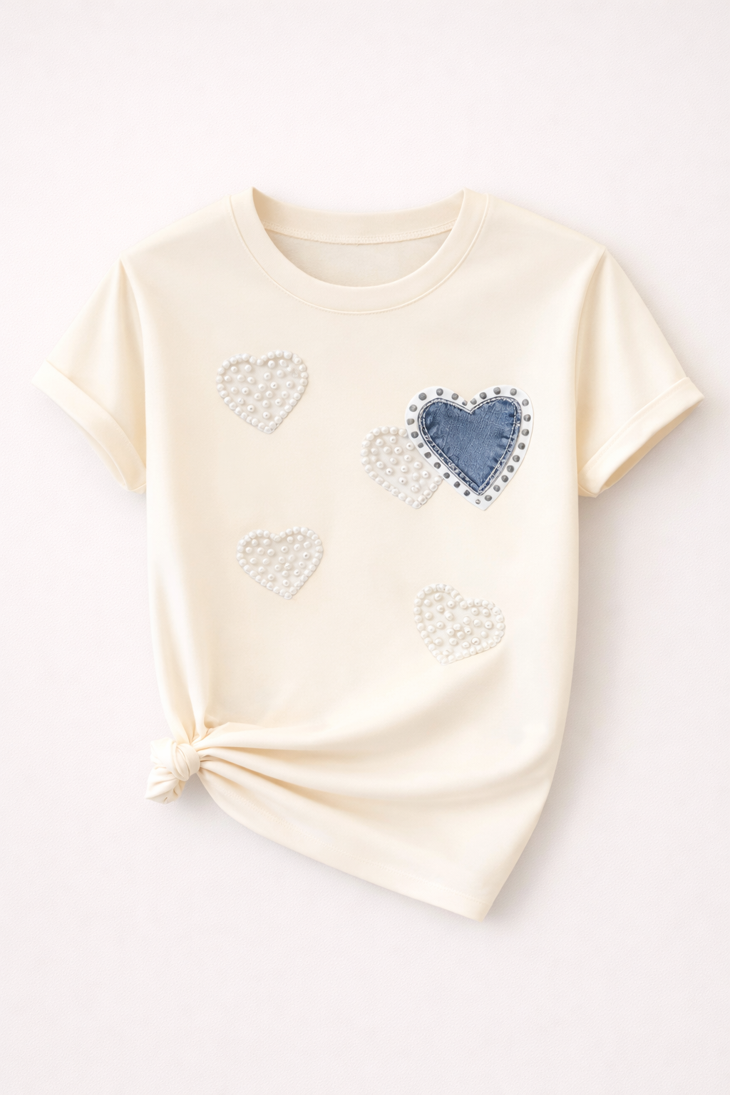 Beige t-shirt with heart designs on a white background
