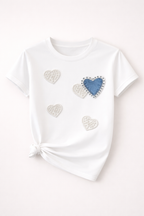 White t-shirt with heart-shaped decorations on a light pink background