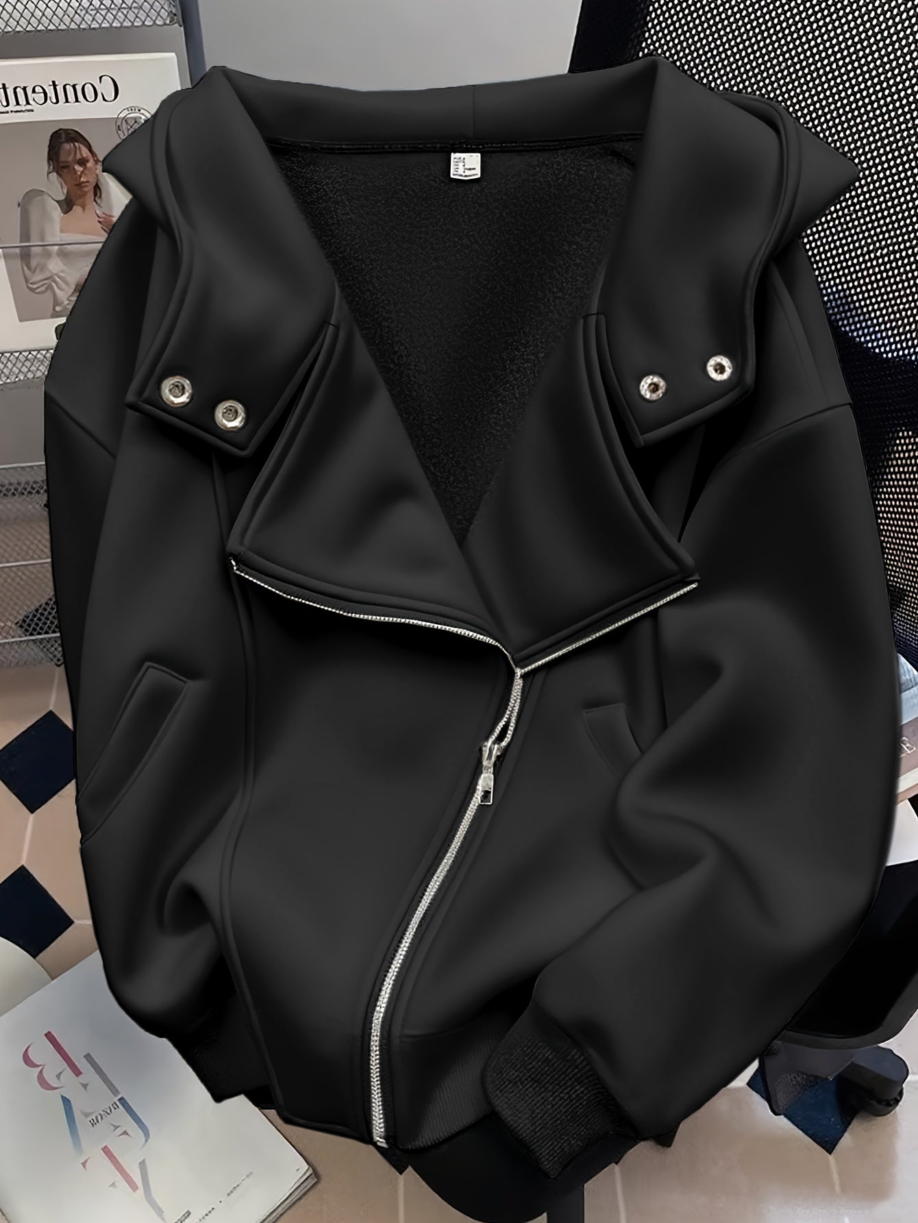 Black jacket with silver zippers on a chair