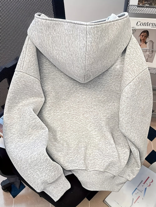Gray hoodie on a chair with a magazine in the background