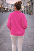 Person wearing a bright pink jacket on a city street