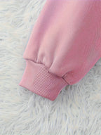 Close-up of a pink sweatshirt on a white fluffy surface