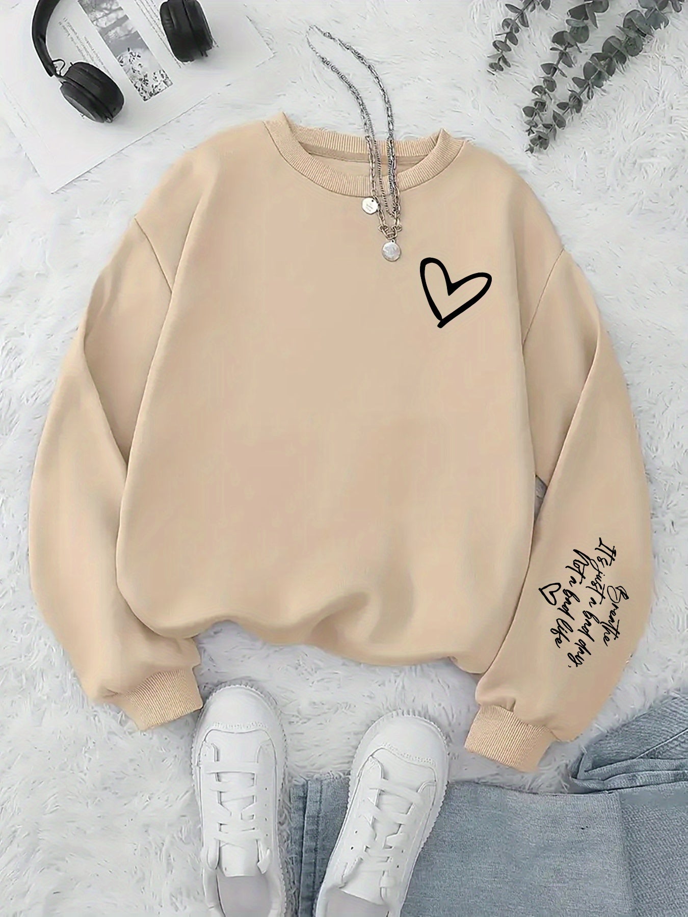 Beige sweatshirt with a heart design on a light gray background