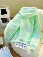 Light green hoodie on a chair with a magazine underneath