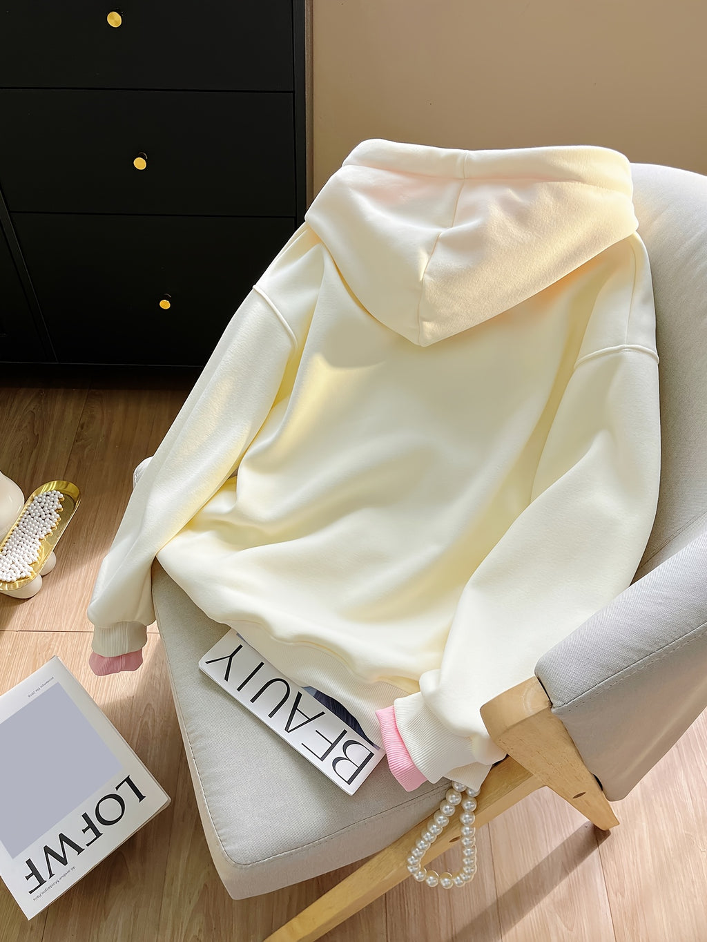 Light-colored hoodie on a chair with a minimal background