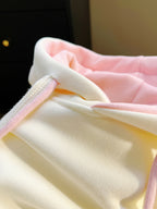 Close-up of a baby outfit with pink and yellow colors.