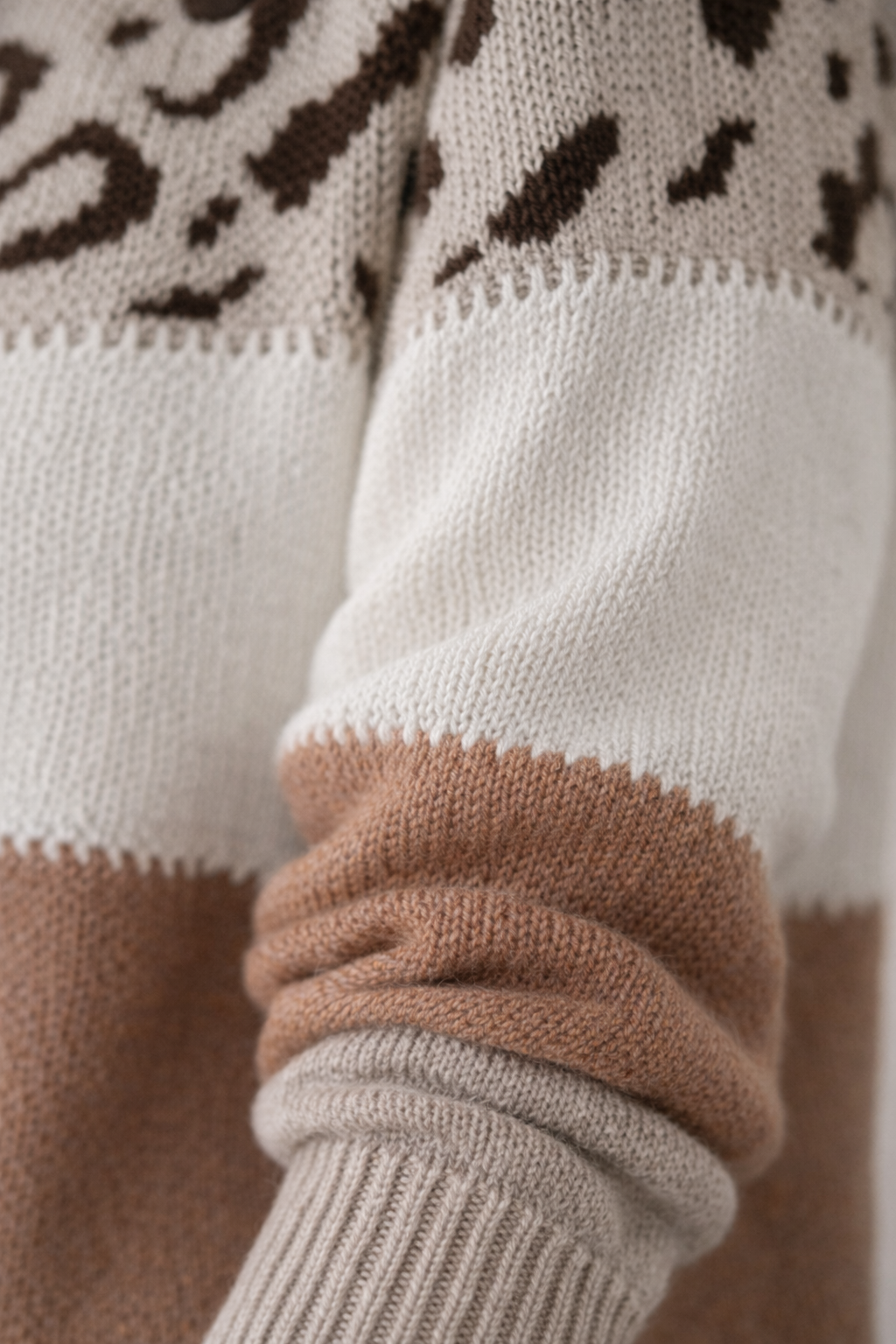 Close-up of a sweater with a patterned sleeve and cuffs.