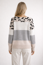 Person wearing a patterned sweater with color-block design on a white background