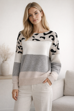 Woman wearing a patterned sweater in a neutral setting