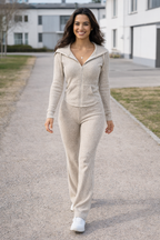 Woman in a beige tracksuit walking on a path outdoors