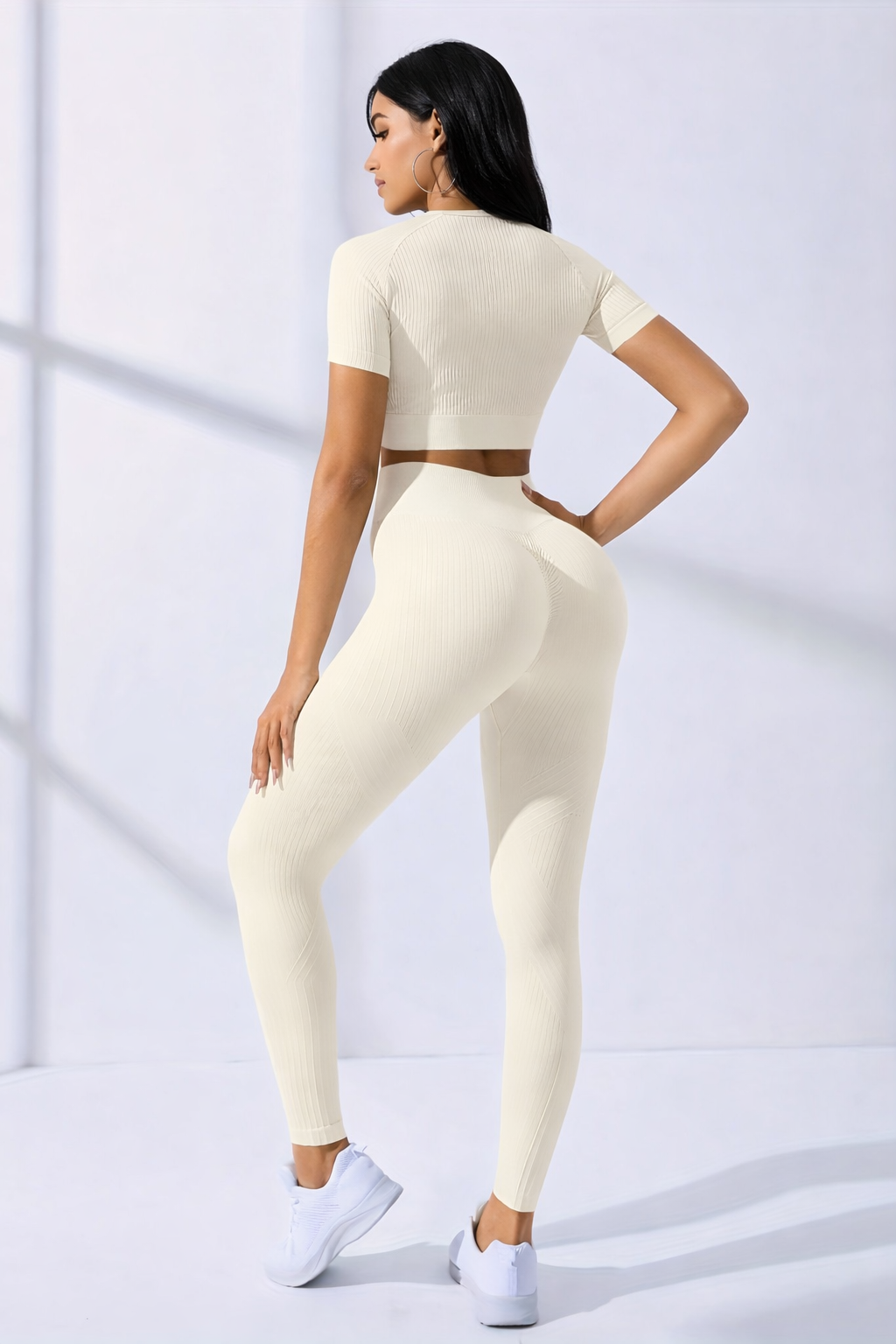 Woman wearing a cream-colored athletic outfit on a white background
