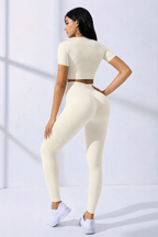 Woman wearing a cream-colored athletic outfit on a white background