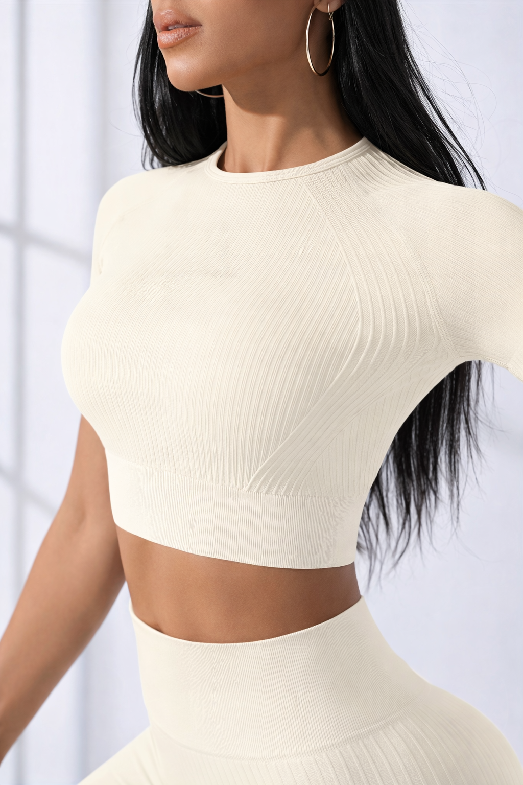 Woman wearing a beige two-piece outfit against a white background