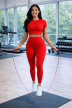 Woman in red athletic wear using a jump rope in a gym setting