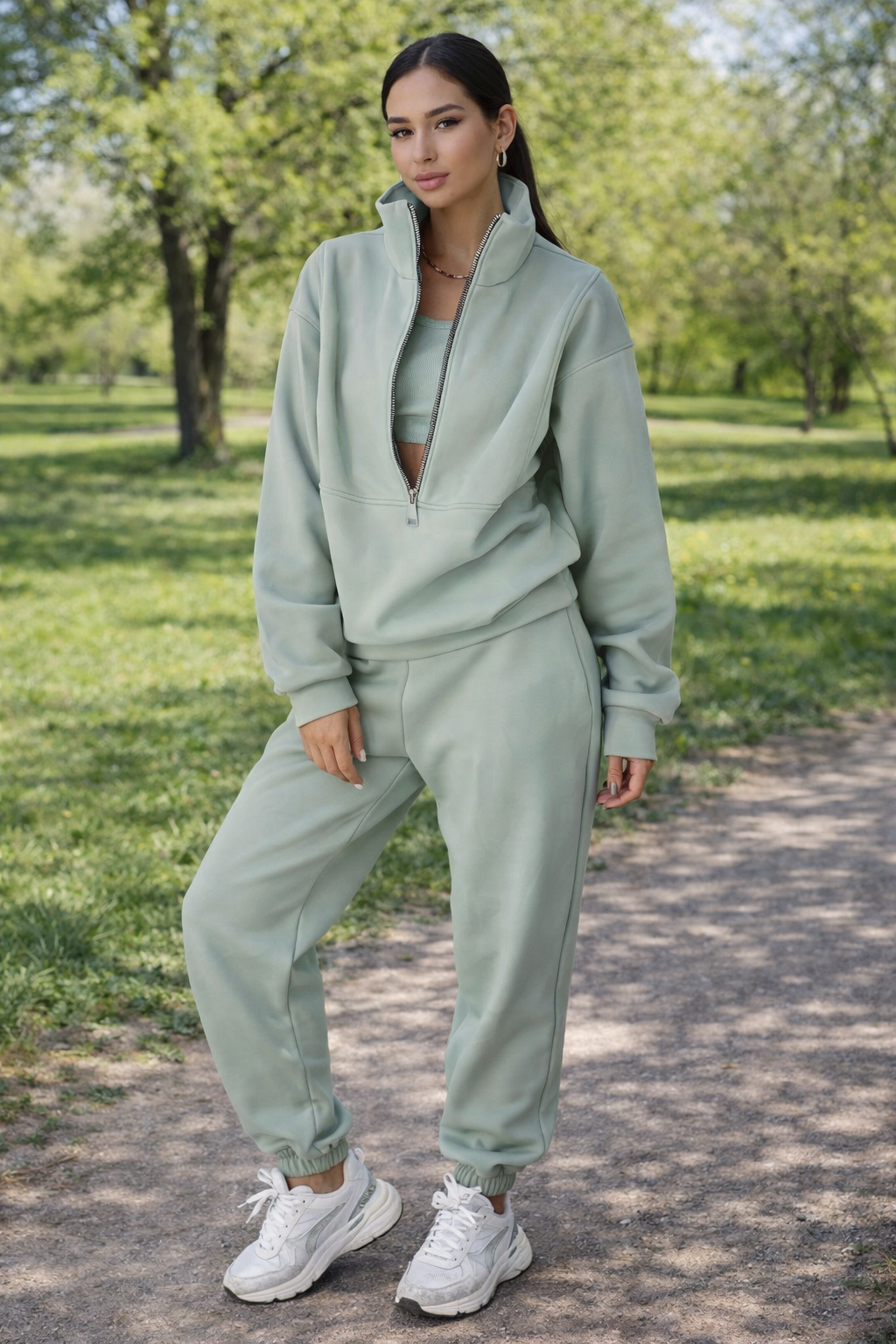 Woman in a light green tracksuit standing in a park