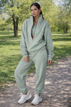 Woman in a light green tracksuit standing in a park